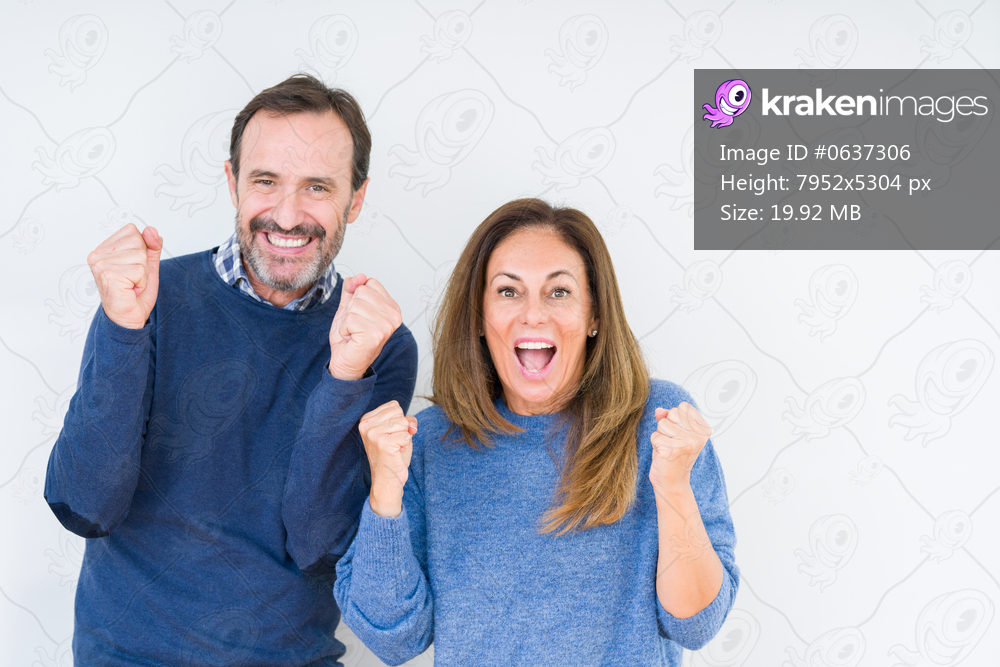 Beautiful middle age couple in love over isolated background celebrating surprised and amazed for success with arms raised and open eyes. Winner concept.