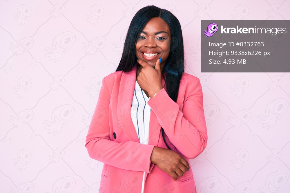 Young african american woman wearing business clothes looking confident at the camera smiling with crossed arms and hand raised on chin. thinking positive. 