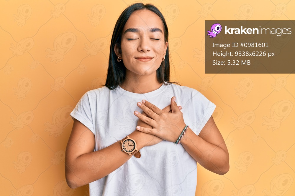 Young asian woman wearing casual white t shirt smiling with hands on chest, eyes closed with grateful gesture on face. health concept. 