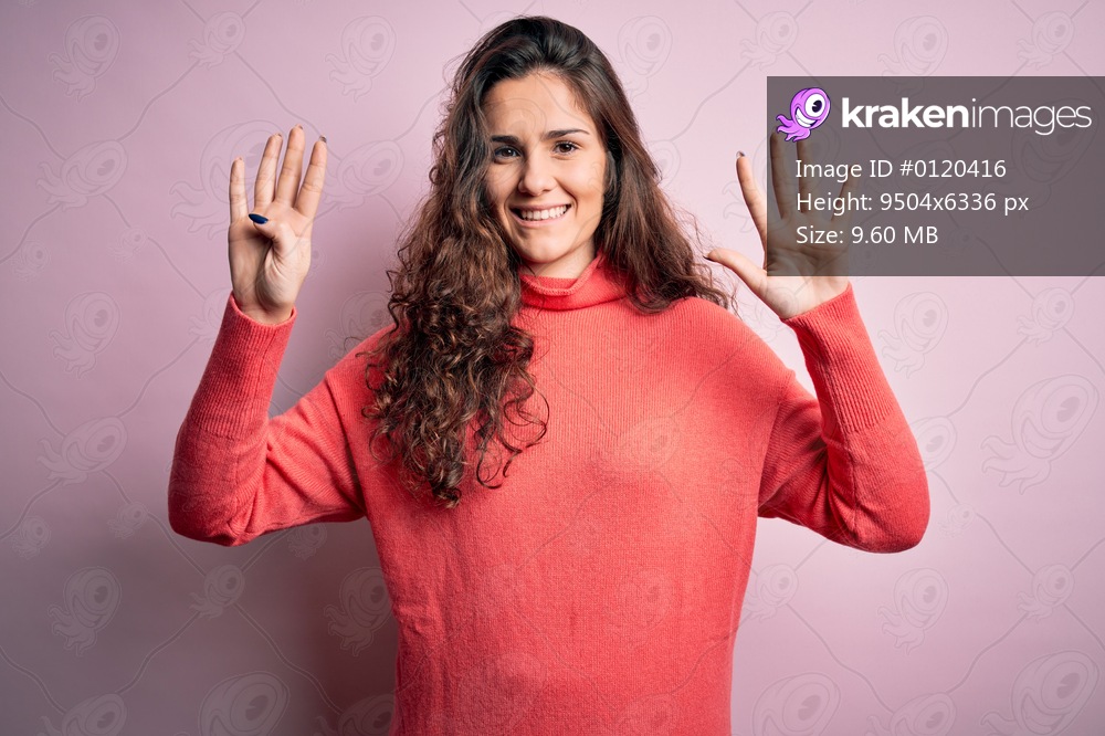 Young beautiful woman with curly hair wearing turtleneck sweater over pink background showing and pointing up with fingers number nine while smiling confident and happy.