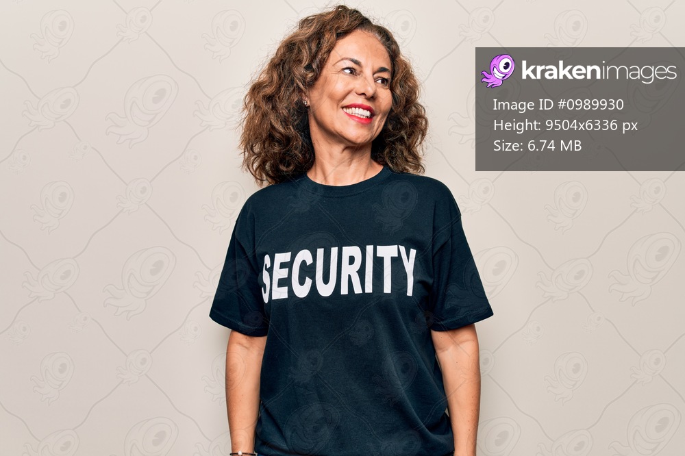Middle age beautiful guard woman wearing security t-shirt uniform over white background looking to side, relax profile pose with natural face and confident smile.