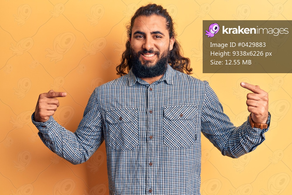 Young arab man wearing casual clothes looking confident with smile on face, pointing oneself with fingers proud and happy. 