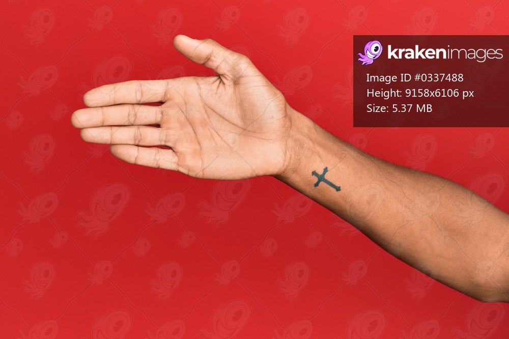 Hand of hispanic man over red isolated background stretching and reaching with open hand for handshake, showing palm 