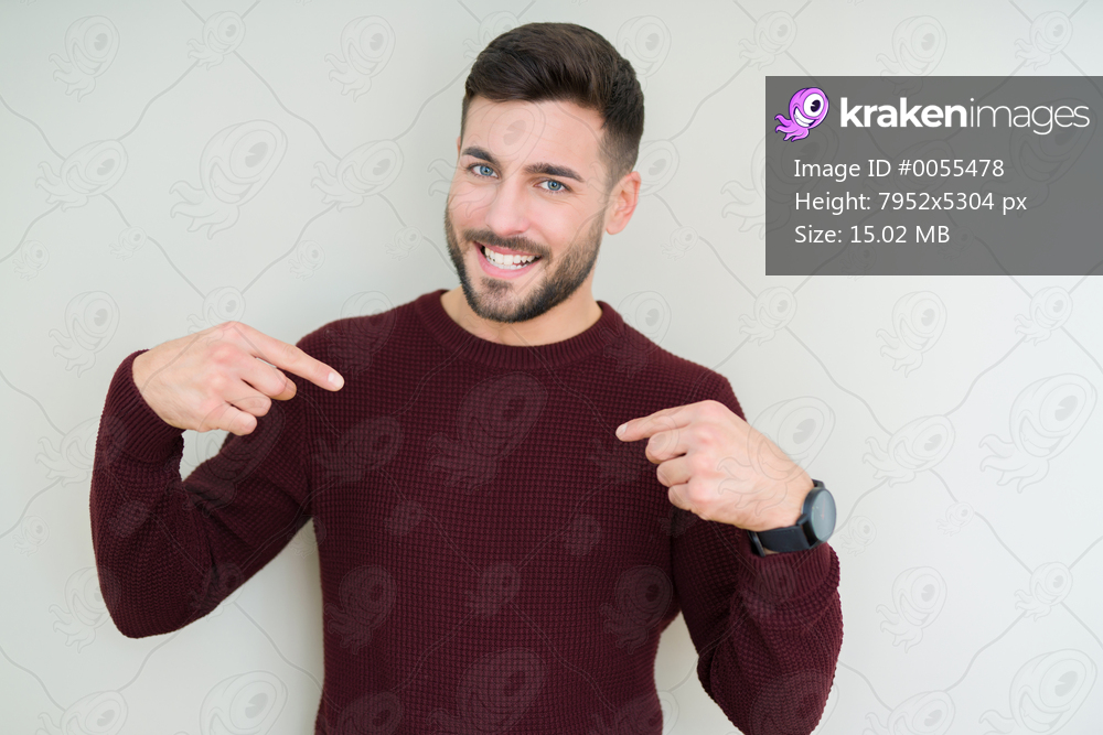 Young handsome man wearing a sweater over isolated background looking confident with smile on face, pointing oneself with fingers proud and happy.