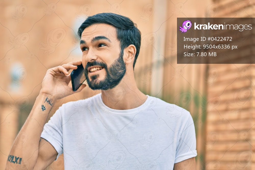 Young hispanic man smiling happy talking on the smartphone at the city.