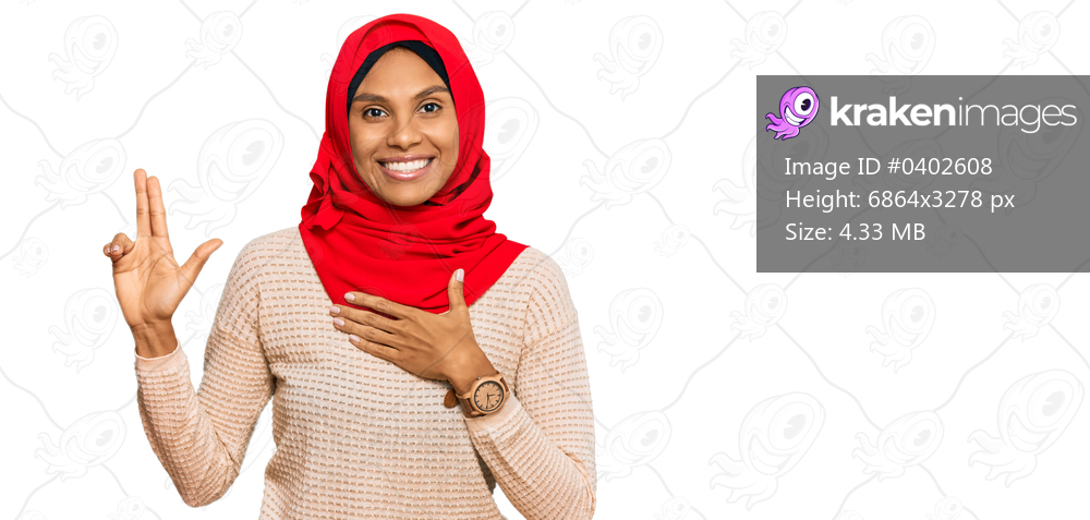 Young african american woman wearing traditional islamic hijab scarf smiling swearing with hand on chest and fingers up, making a loyalty promise oath 