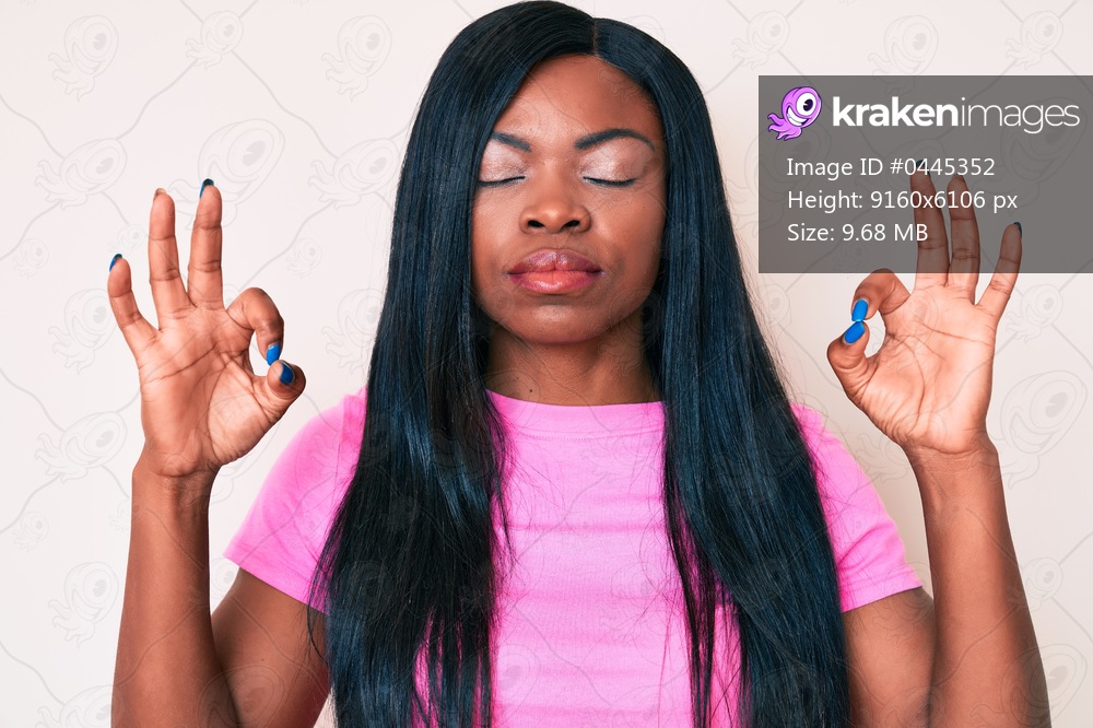 Young african american woman wearing casual clothes relax and smiling with eyes closed doing meditation gesture with fingers. yoga concept. 