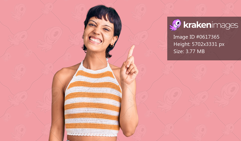 Young brunette woman with short hair wearing casual clothes pointing finger up with successful idea. exited and happy. number one. 