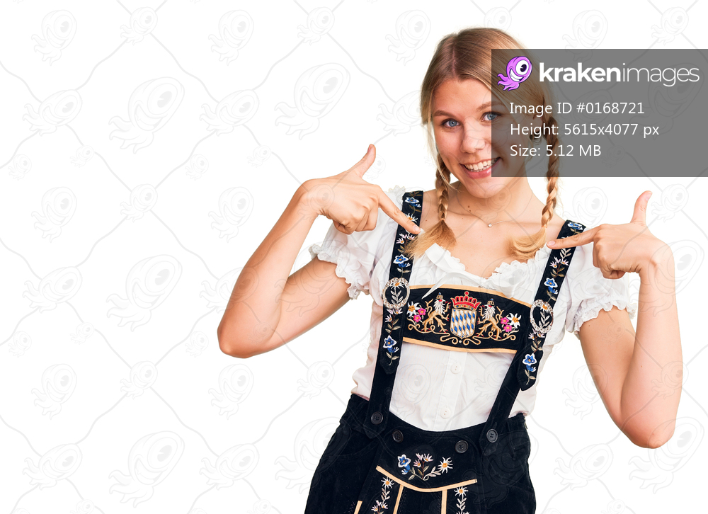 Young beautiful blonde woman wearing oktoberfest dress looking confident with smile on face, pointing oneself with fingers proud and happy. 