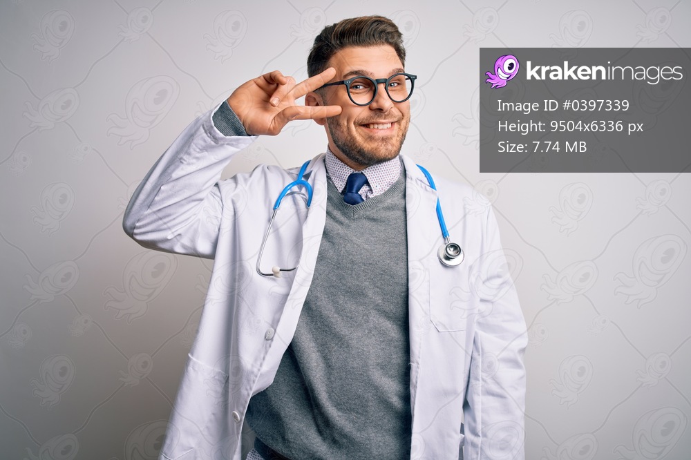 Young doctor man with blue eyes wearing medical coat and stethoscope over isolated background Doing peace symbol with fingers over face, smiling cheerful showing victory