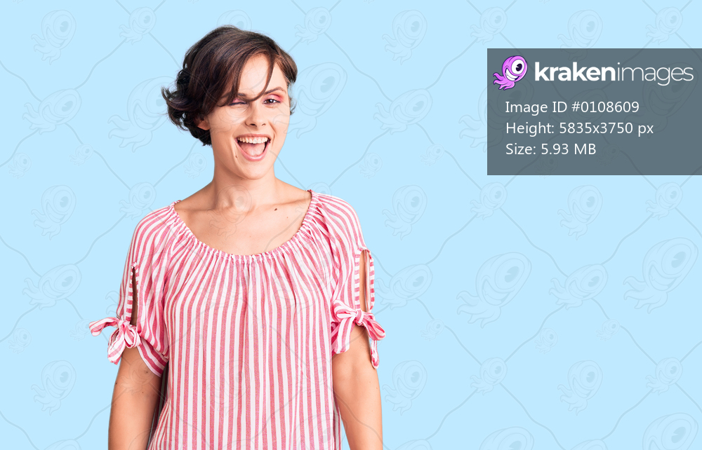 Beautiful young woman with short hair wearing casual summer clothes winking looking at the camera with sexy expression, cheerful and happy face. 