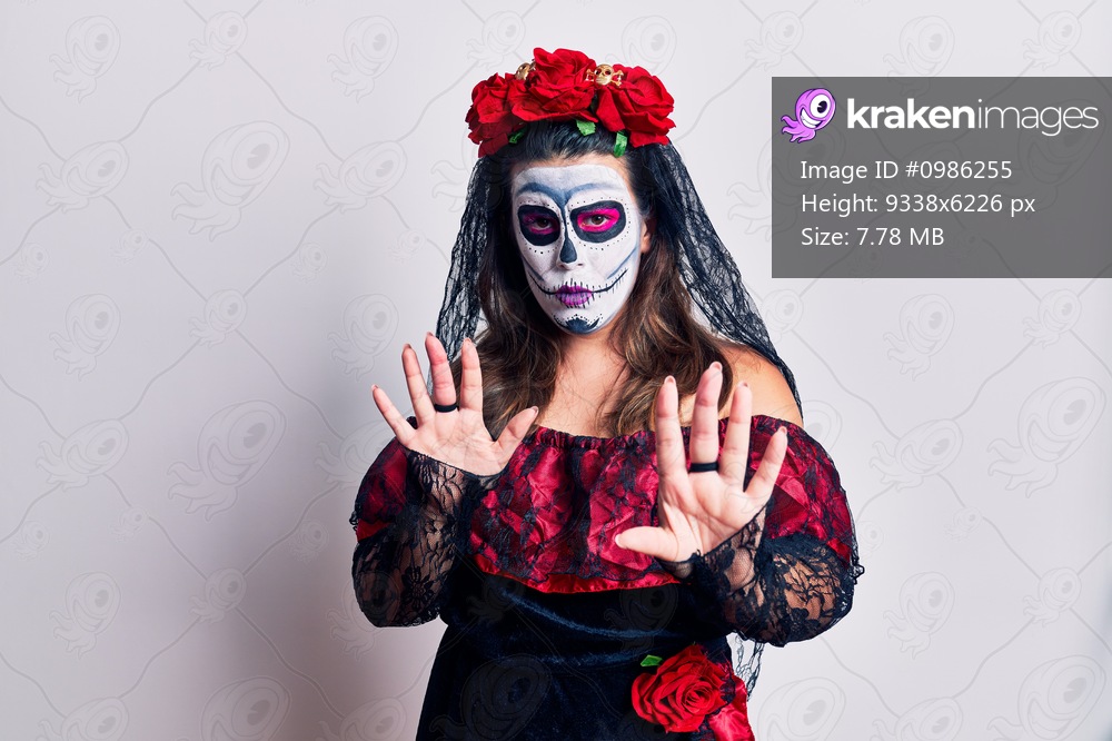 Young woman wearing day of the dead costume over white moving away hands palms showing refusal and denial with afraid and disgusting expression. stop and forbidden. 