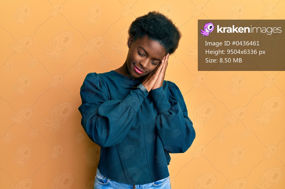 Young african american girl wearing casual clothes sleeping tired dreaming and posing with hands together while smiling with closed eyes. 