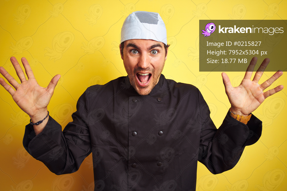 Young handsome chef man cooking wearing uniform and hat over isolated yellow background celebrating crazy and amazed for success with arms raised and open eyes screaming excited. Winner concept