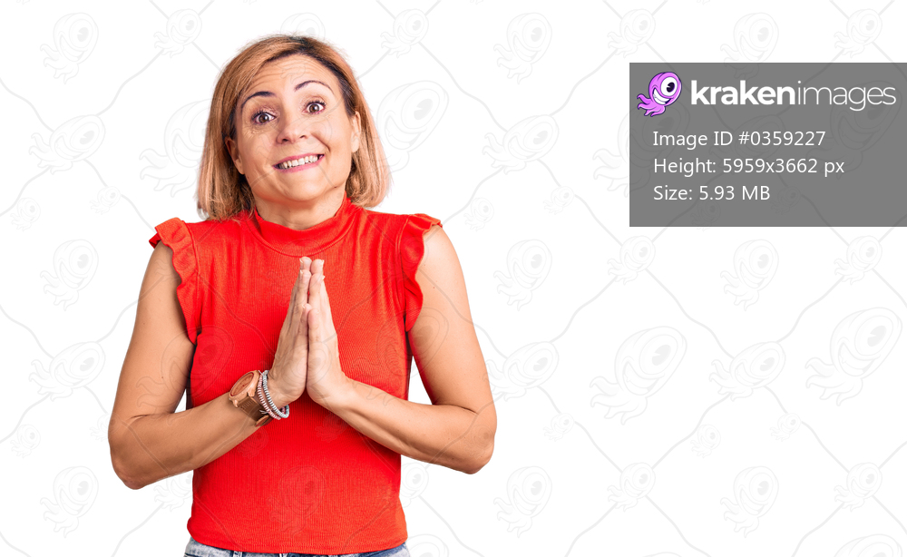 Young blonde woman wearing casual clothes praying with hands together asking for forgiveness smiling confident. 