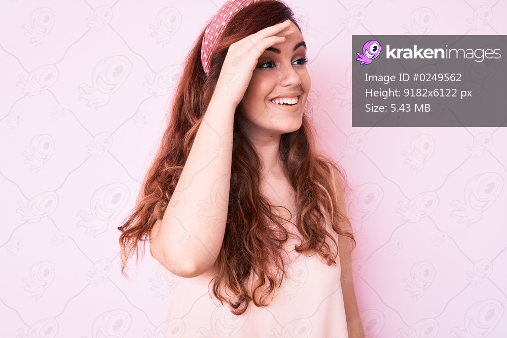 Young beautiful woman wearing casual clothes very happy and smiling looking far away with hand over head. searching concept. 