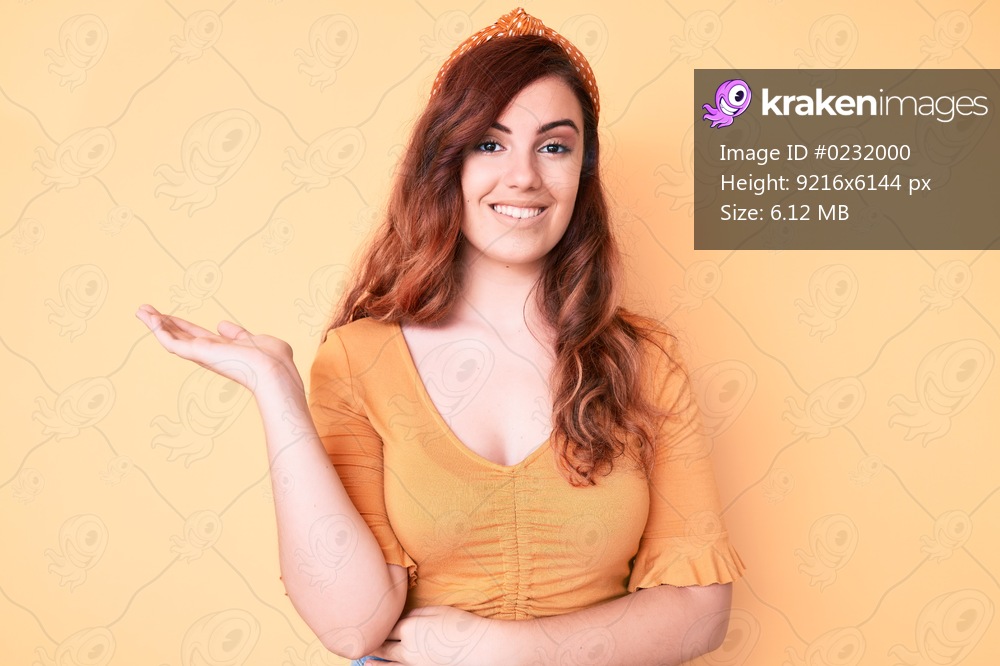 Young beautiful woman wearing casual clothes smiling cheerful presenting and pointing with palm of hand looking at the camera. 