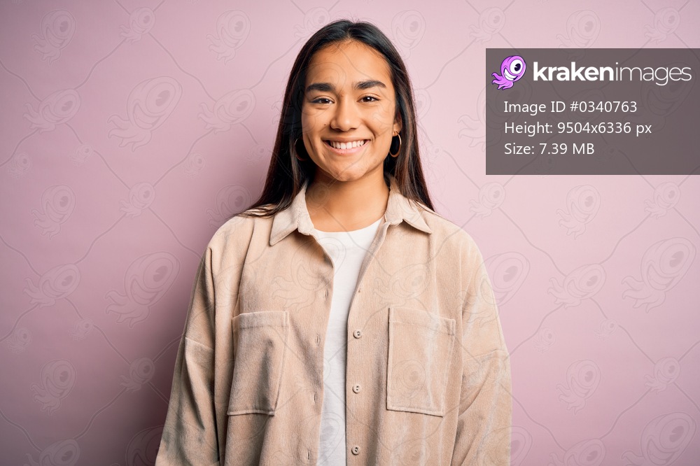 Young beautiful asian woman wearing casual shirt standing over pink background with a happy and cool smile on face. Lucky person.