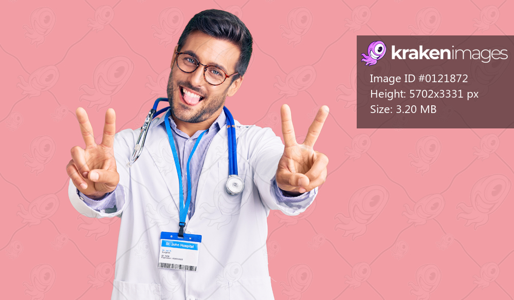 Young hispanic man wearing doctor uniform and stethoscope smiling with tongue out showing fingers of both hands doing victory sign. number two. 