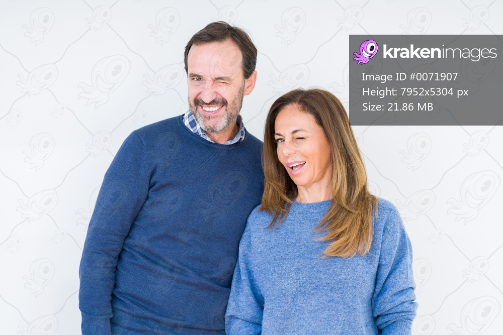 Beautiful middle age couple in love over isolated background winking looking at the camera with sexy expression, cheerful and happy face.