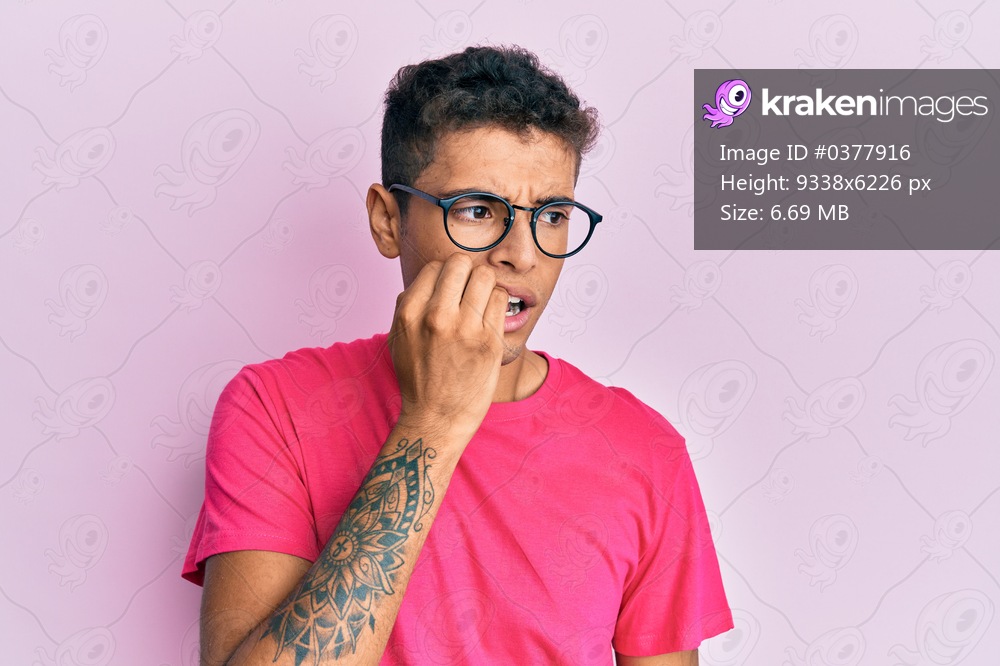 Young handsome african american man wearing glasses over pink background looking stressed and nervous with hands on mouth biting nails. anxiety problem. 