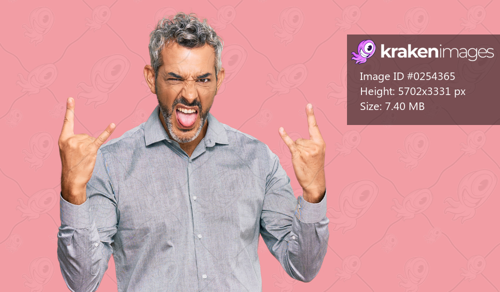 Middle age grey-haired man wearing casual clothes shouting with crazy expression doing rock symbol with hands up. music star. heavy concept. 
