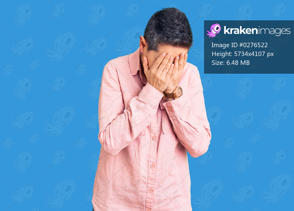 Young woman with short hair wearing casual clothes with sad expression covering face with hands while crying. depression concept. 