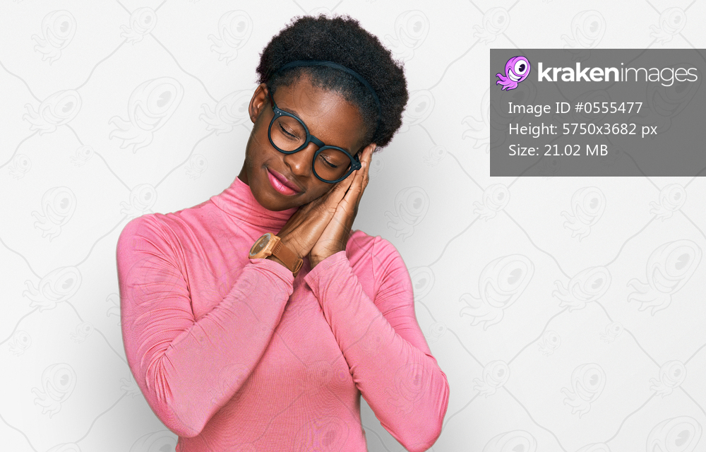 Young african american girl wearing casual clothes and glasses sleeping tired dreaming and posing with hands together while smiling with closed eyes. 