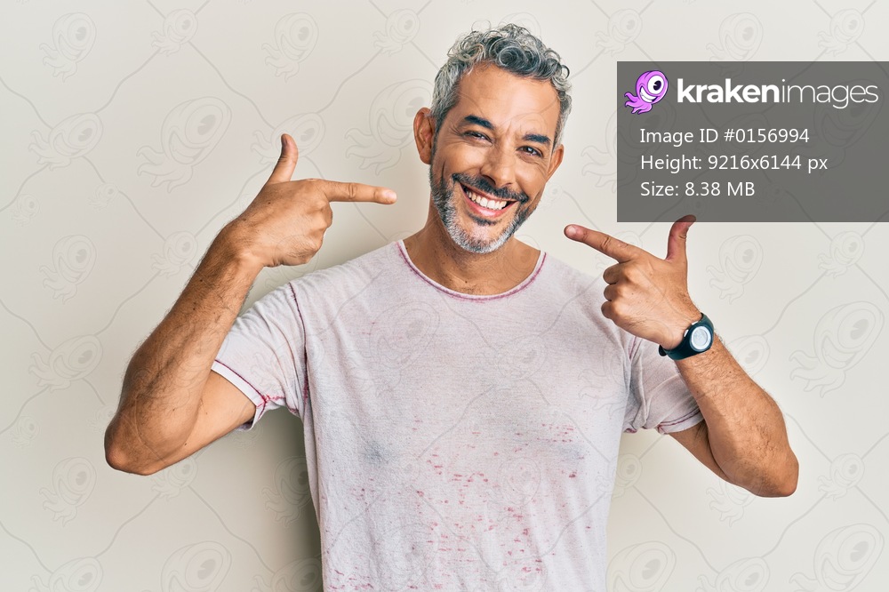 Middle age grey-haired man wearing casual clothes smiling cheerful showing and pointing with fingers teeth and mouth. dental health concept. 