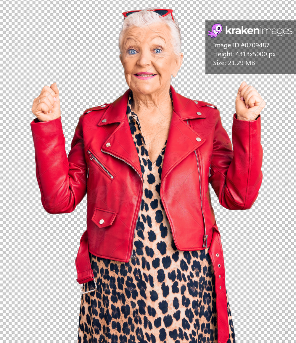 Senior beautiful woman with blue eyes and grey hair wearing a modern style with a red leather jacket screaming proud, celebrating victory and success very excited with raised arms