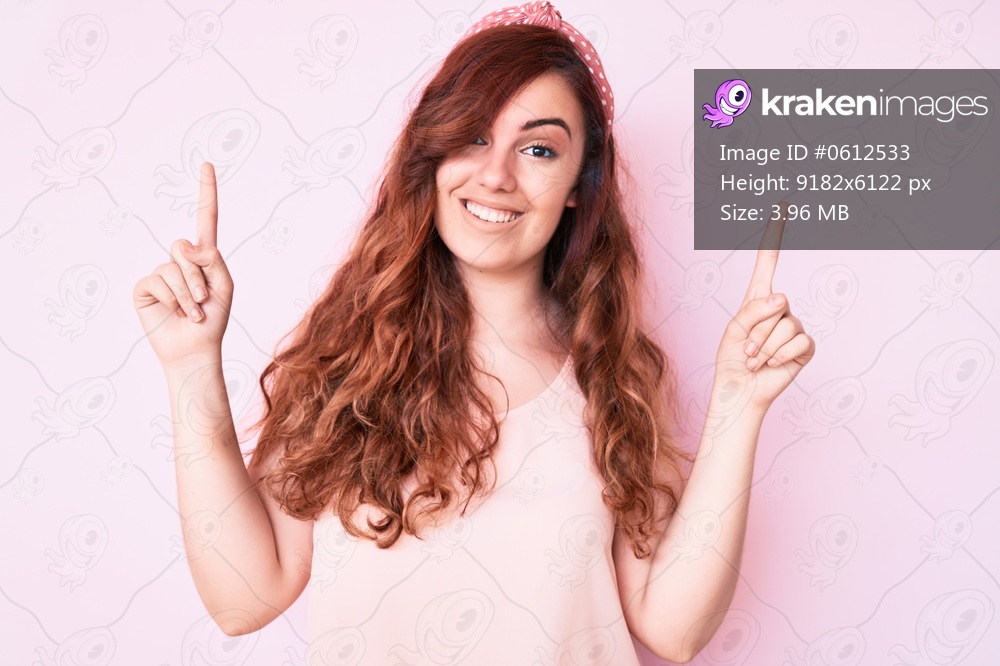 Young beautiful woman wearing casual clothes smiling amazed and surprised and pointing up with fingers and raised arms. 