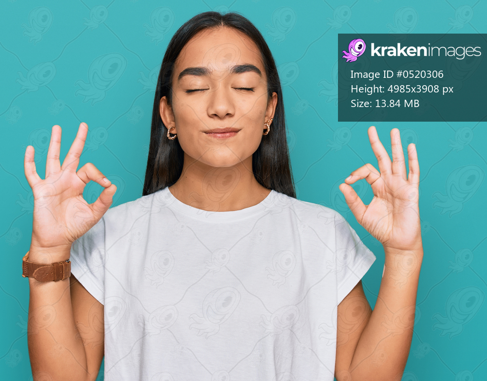 Young asian woman wearing casual white t shirt relax and smiling with eyes closed doing meditation gesture with fingers. yoga concept. 