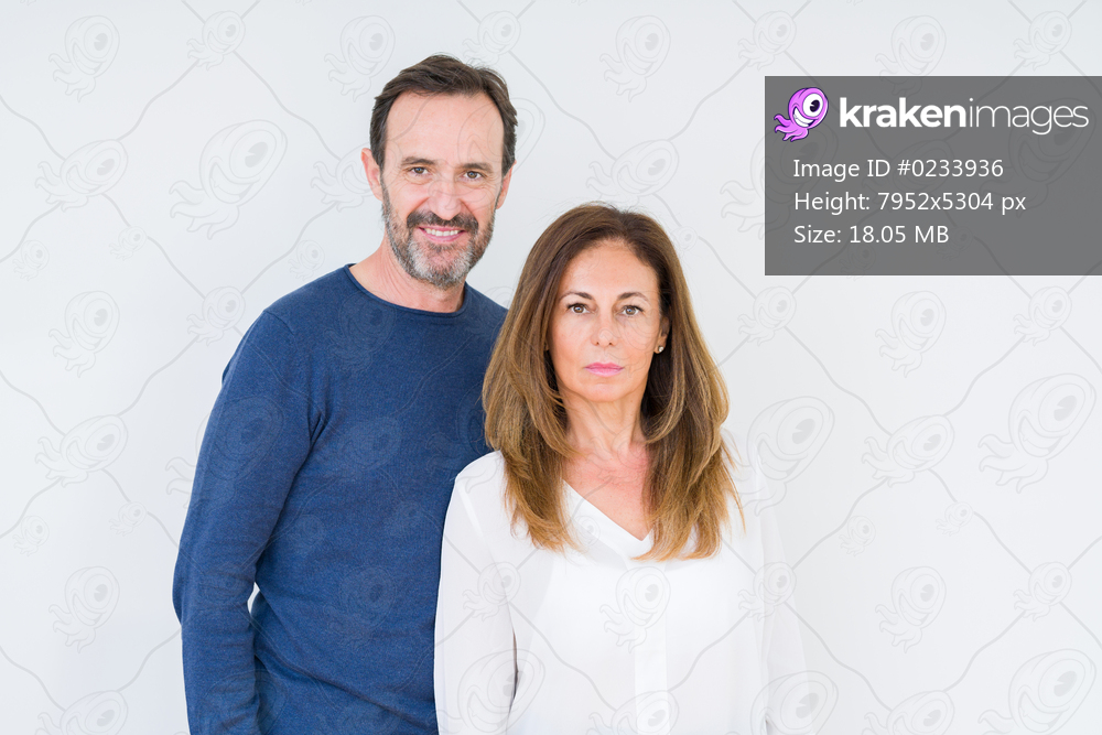 Beautiful middle age couple in love over isolated background Relaxed with serious expression on face. Simple and natural looking at the camera.