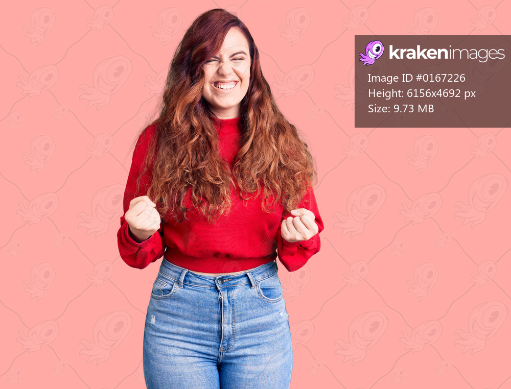 Young beautiful woman wearing casual winter sweater very happy and excited doing winner gesture with arms raised, smiling and screaming for success. celebration concept. 