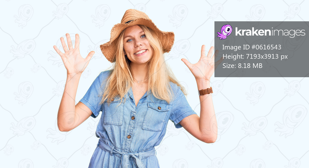 Young beautiful blonde woman wearing summer hat and dress showing and pointing up with fingers number ten while smiling confident and happy. 