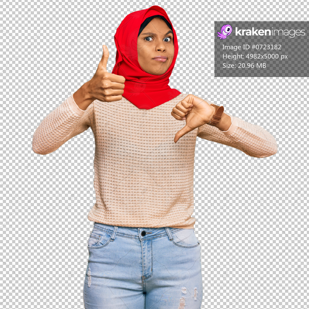 Young african american woman wearing traditional islamic hijab scarf doing thumbs up and down, disagreement and agreement expression. crazy conflict