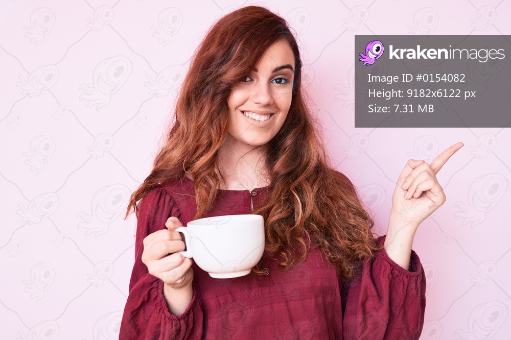Young beautiful woman holding coffee smiling happy pointing with hand and finger to the side 