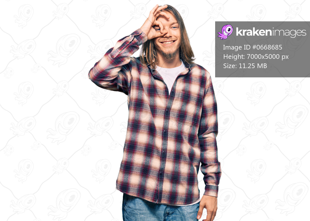 Handsome caucasian man with long hair wearing hipster shirt doing ok gesture with hand smiling, eye looking through fingers with happy face. 