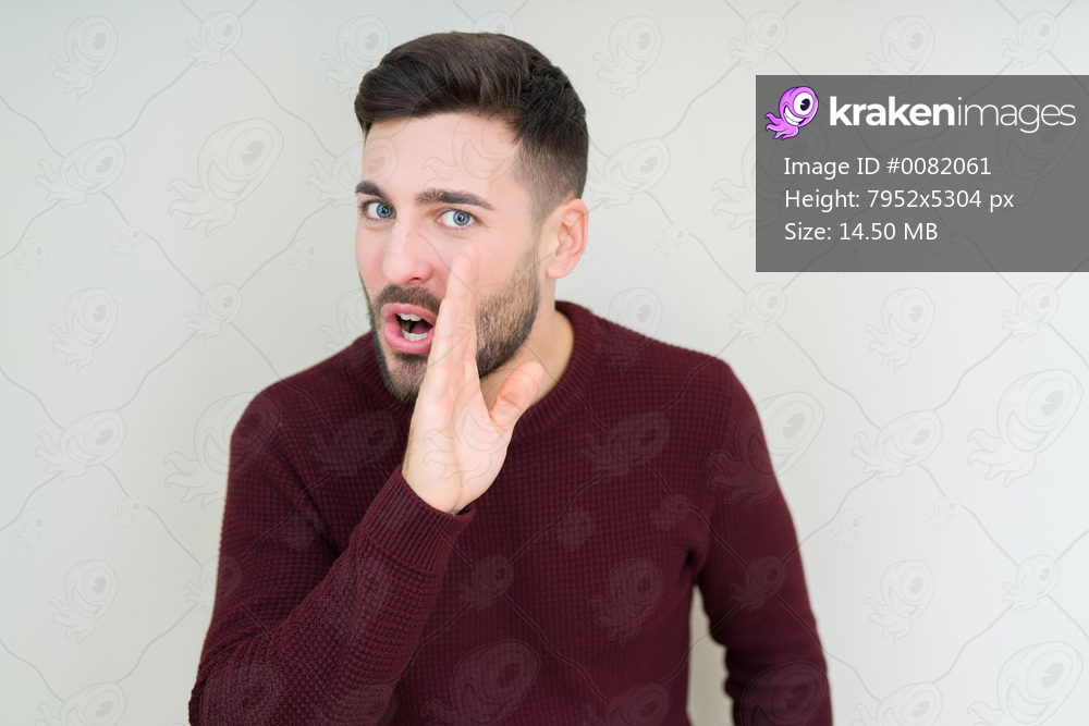 Young handsome man wearing a sweater over isolated background hand on mouth telling secret rumor, whispering malicious talk conversation