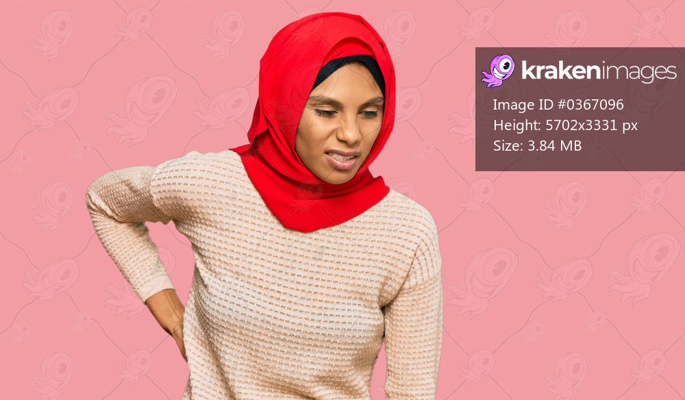 Young african american woman wearing traditional islamic hijab scarf suffering of backache, touching back with hand, muscular pain 
