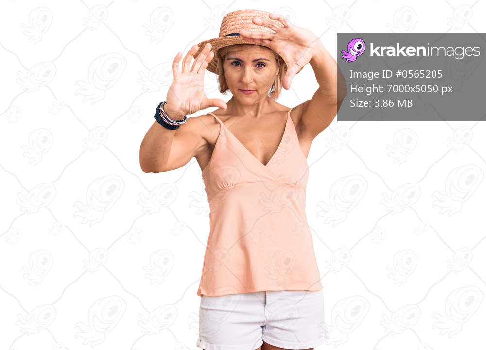 Young blonde woman wearing summer hat doing frame using hands palms and fingers, camera perspective 