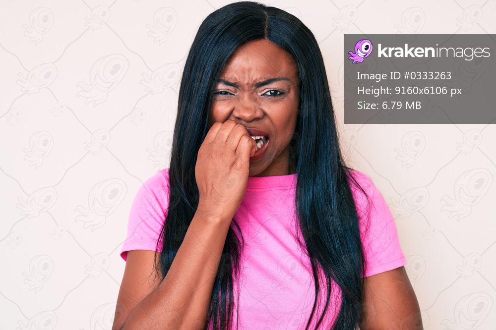 Young african american woman wearing casual clothes looking stressed and nervous with hands on mouth biting nails. anxiety problem. 