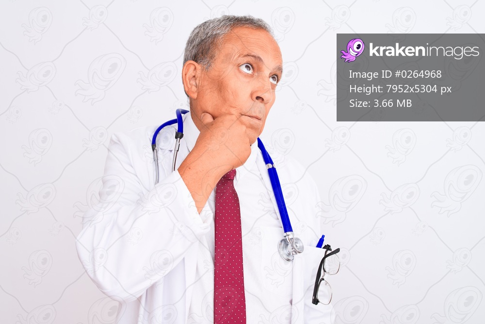 Senior grey-haired doctor man wearing stethoscope standing over isolated white background with hand on chin thinking about question, pensive expression. Smiling with thoughtful face. Doubt concept.