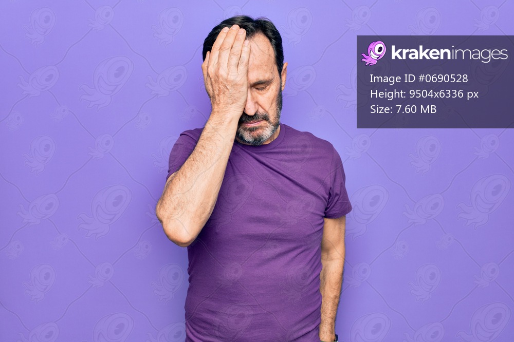 Middle age handsome man wearing casual purple t-shirt standing over isolated background surprised with hand on head for mistake, remember error. Forgot, bad memory concept.