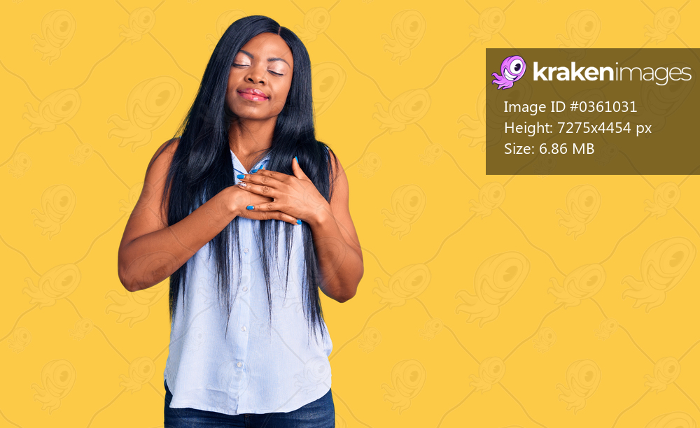 Young african american woman wearing casual clothes smiling with hands on chest with closed eyes and grateful gesture on face. health concept. 