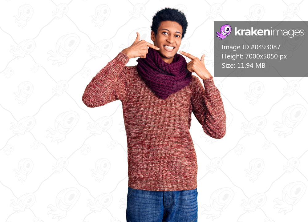 Young african american man wearing casual winter sweater and scarf smiling cheerful showing and pointing with fingers teeth and mouth. dental health concept. 