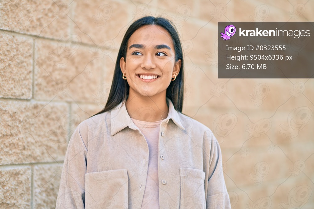 Young latin girl smiling happy standing at the city.