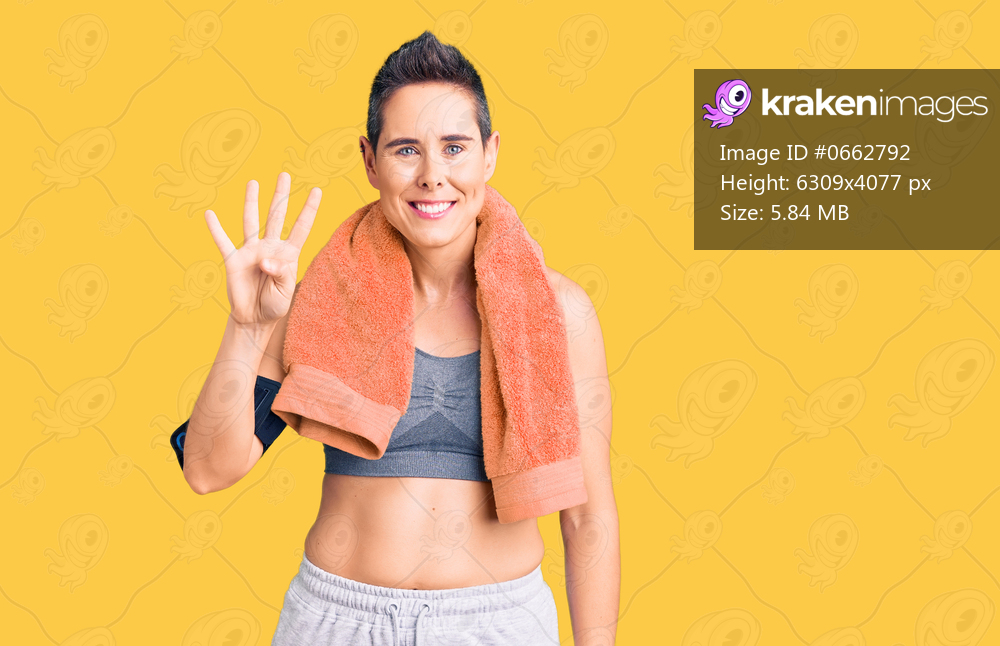 Young woman with short hair wearing sportswear and towel using smartphone showing and pointing up with fingers number four while smiling confident and happy. 