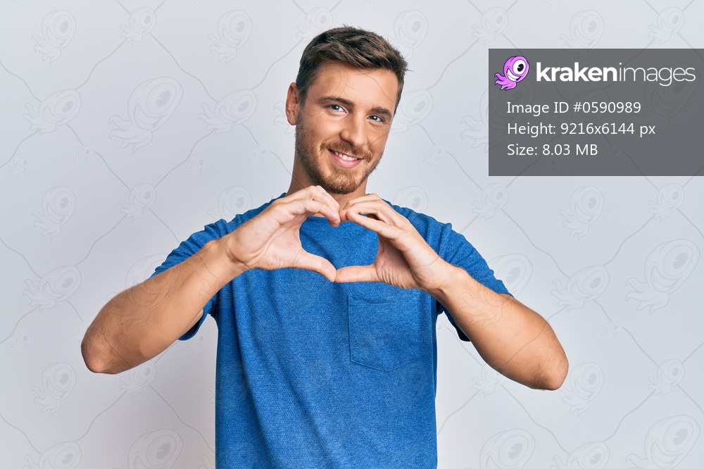 Handsome caucasian man wearing casual clothes smiling in love doing heart symbol shape with hands. romantic concept. 