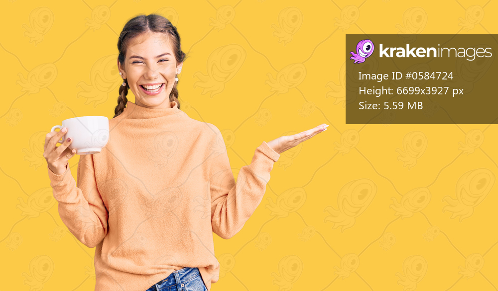 Beautiful caucasian woman with blonde hair drinking a coffee celebrating victory with happy smile and winner expression with raised hands 